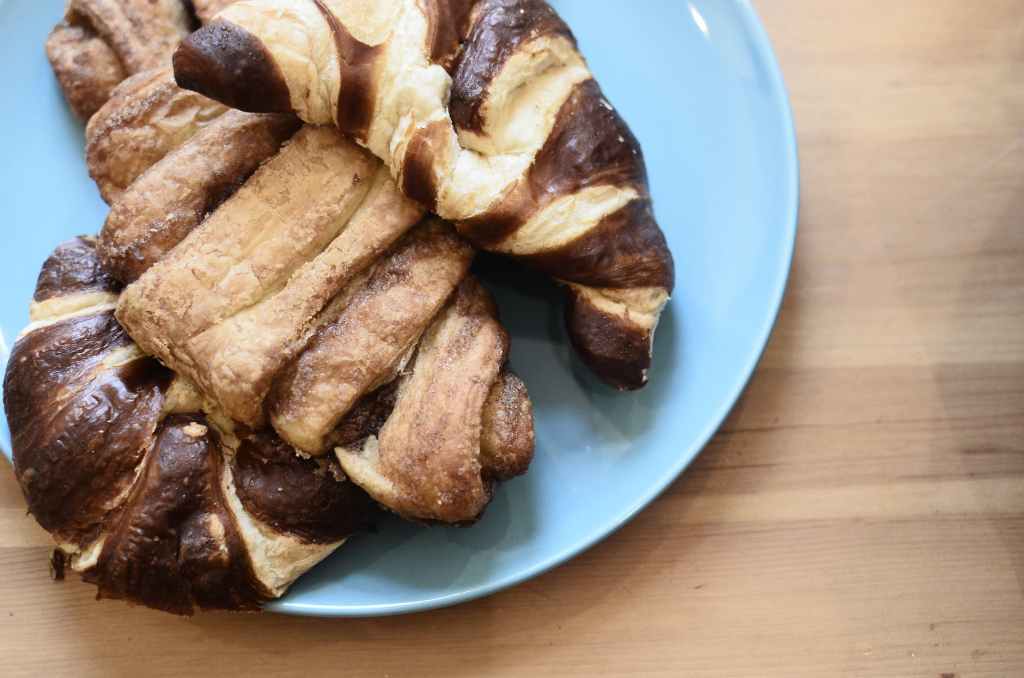 fresh sweet croissants on ceramic plate