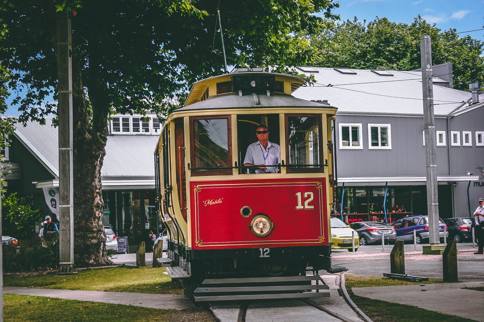 man riding on red and beige train
