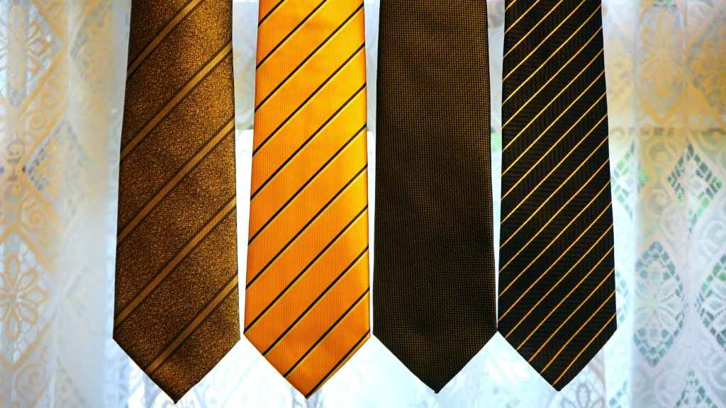 four assorted color neckties on gray textile